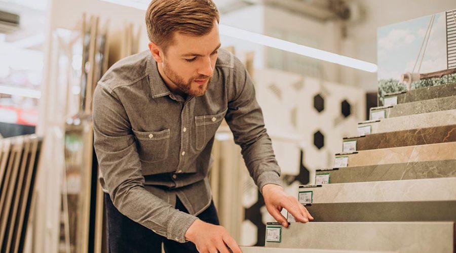 young man choosing tiles building market