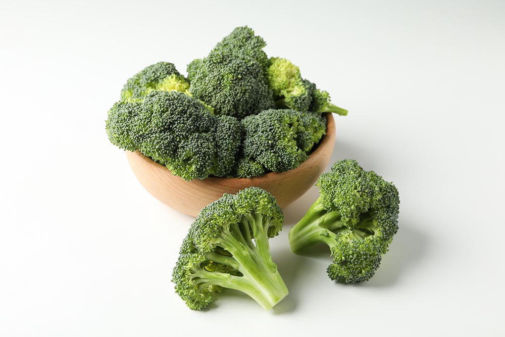 Bowl and broccoli on white background. Fresh vegetable