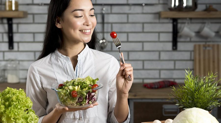 smiling asian woman with healthy salad kitchen